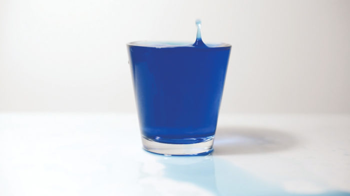 Anna Raimondo, Mediterranio, vidéo dans laquelle une verre d'eau bleu se rempli goutte à goutte alors que l'artiste énumère en boucle le mot 