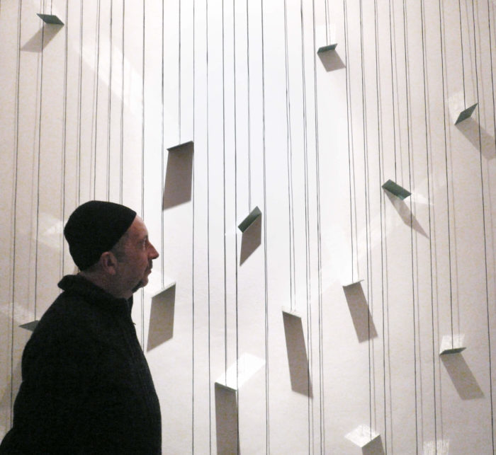 Josep Ginestar devant son installation constituée de miroirs et d'écritures qui se reflètent sur les murs du Cube - independent art room à Rabat, Maroc