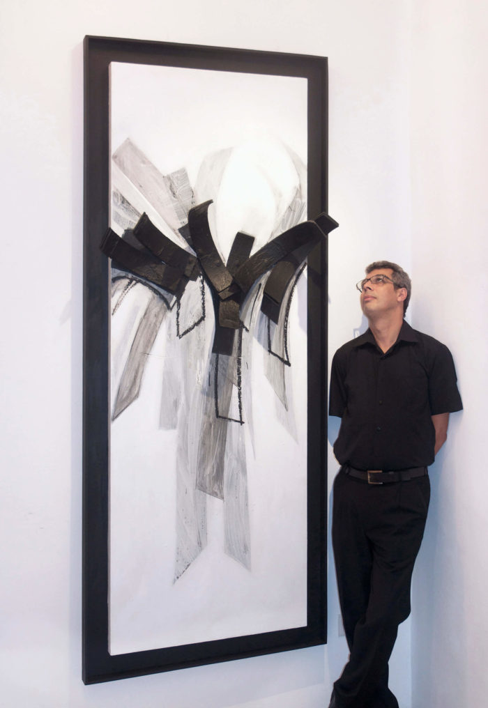 Hassan Echair devant un de ses tableau au Cube - independent art room, Rabat, Maroc